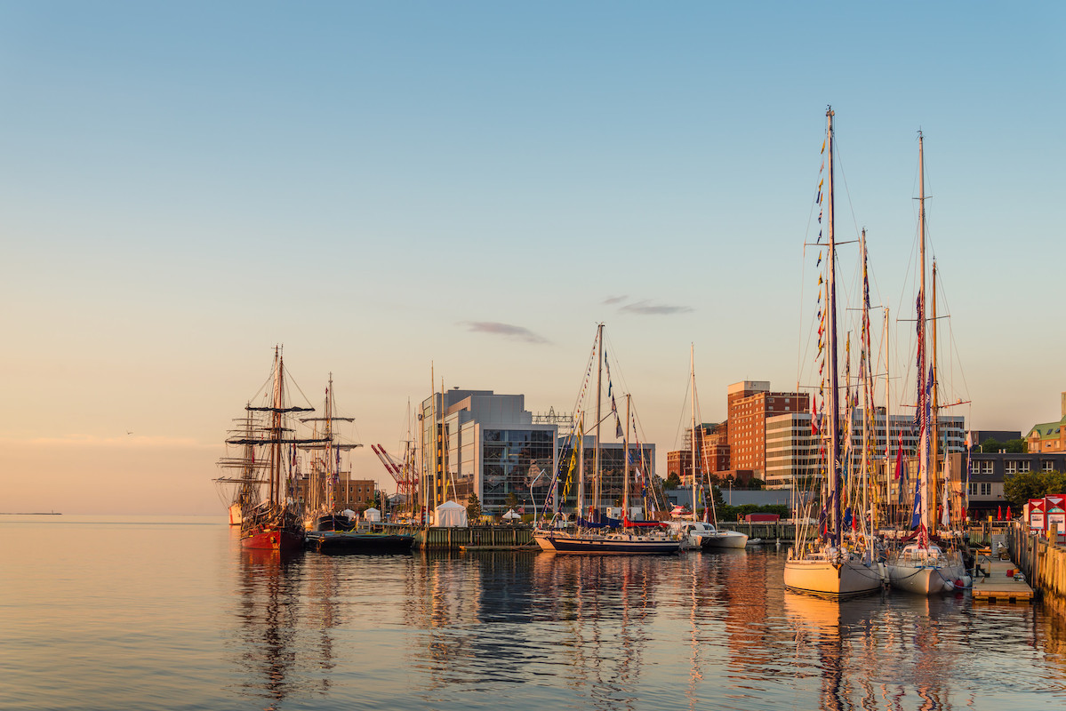 Halifax Harbour in the early morning light with sailboats docked along the boardwalk.