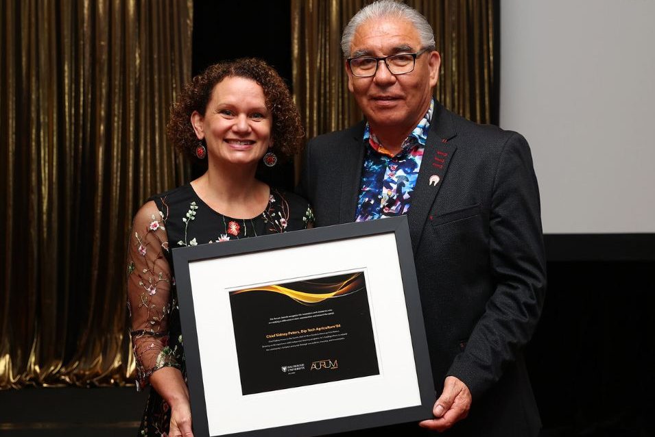 Sheila Blair-Reid presents a framed Aurum Awards certificate to Chief Sidney Peters.
