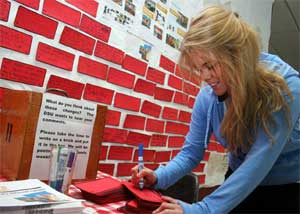 Student writing on brick