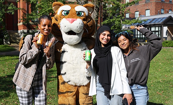 Three students are posing with the Dal Tiger mascot.