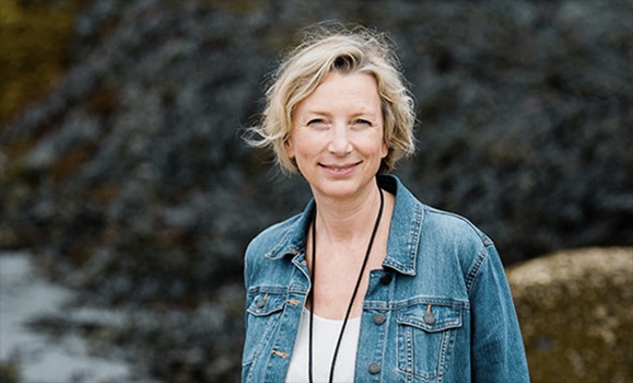 Dr. Katja Fennel is wearing a jean jacket and lanyard and looking at the camera.