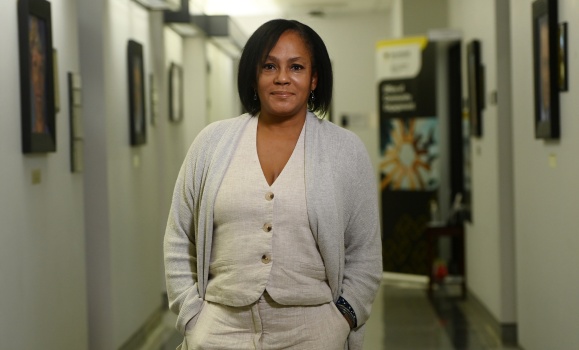 Dr. Gaynor Watson-Creed is standing in a hallway with her hands in her pocket.