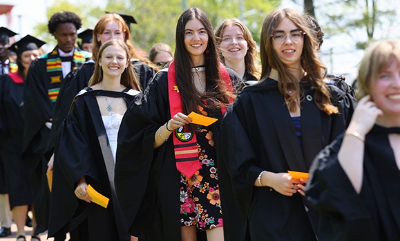 Graduates are lined up outside in their gowns.