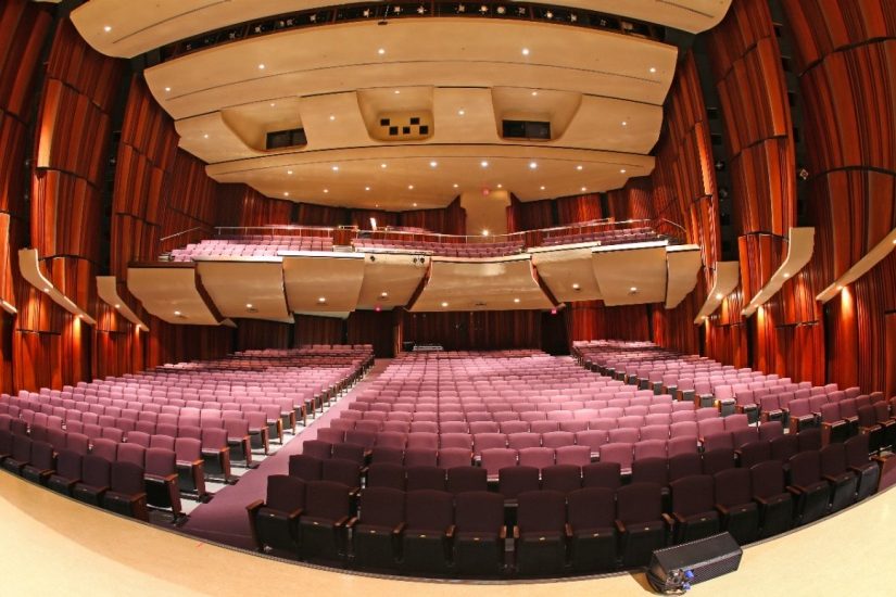 Empty auditorium with red walls and seats.
