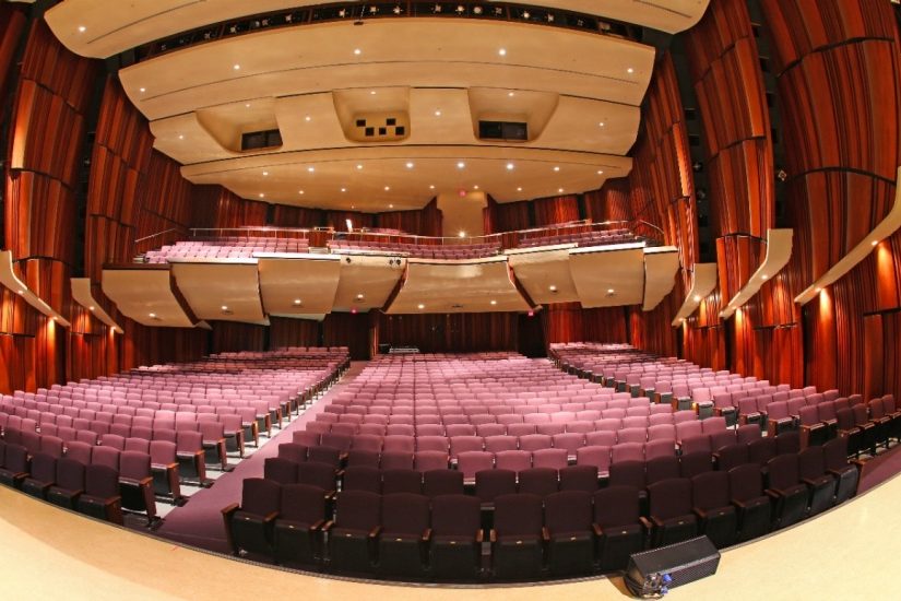 Empty auditorium with red walls and seats.