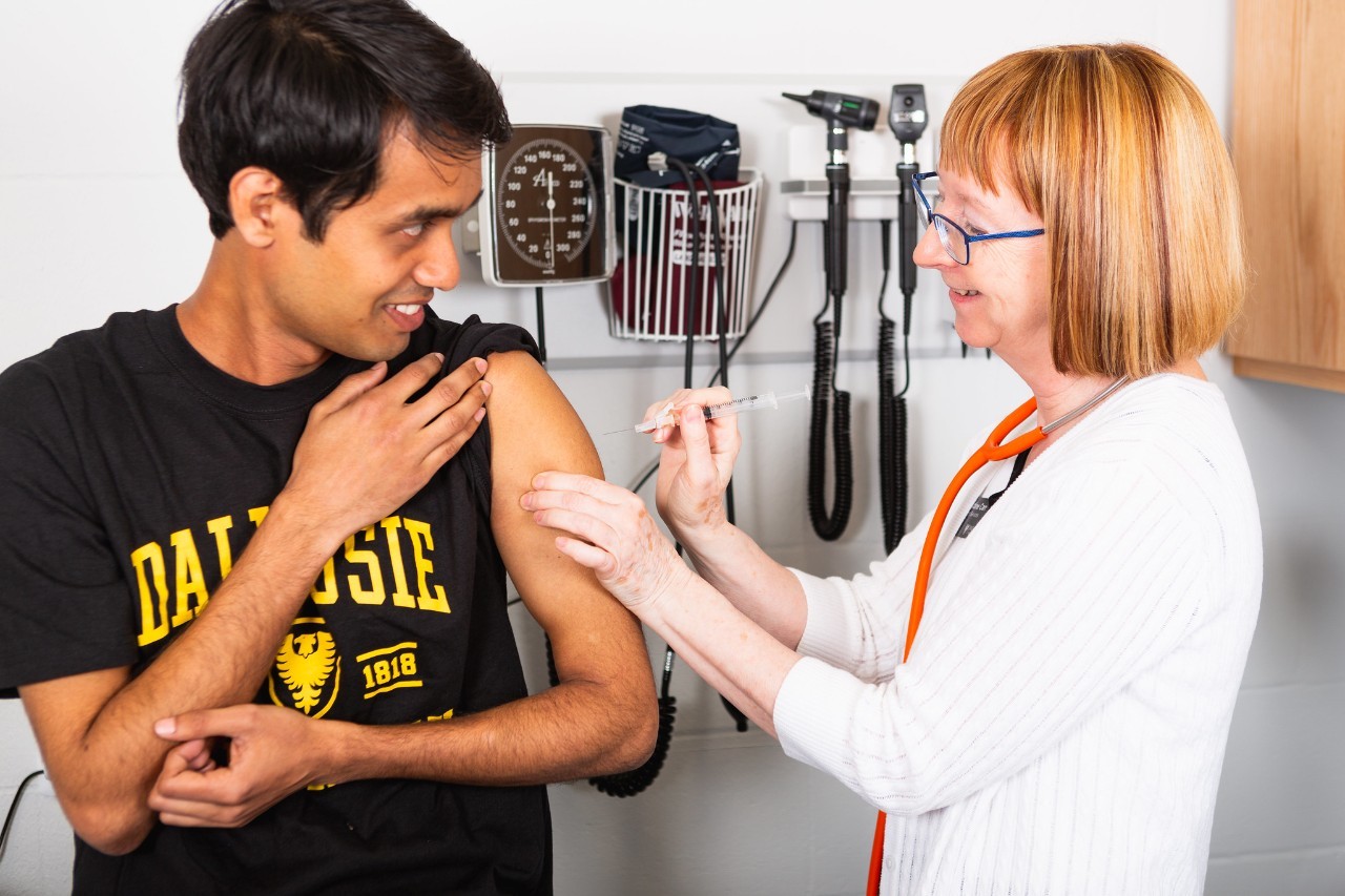 nurse gives a student the flu shot