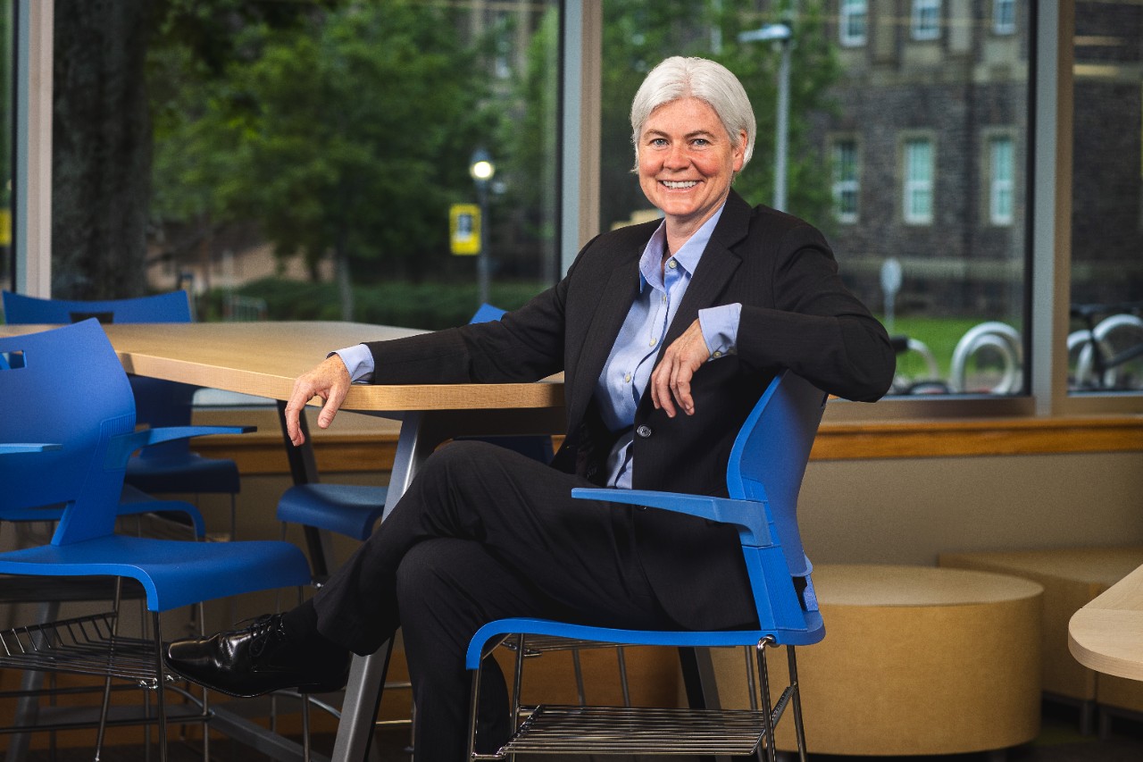Dalhousie's 13th President, Kim Brooks, sits smiling in a blue chair. 