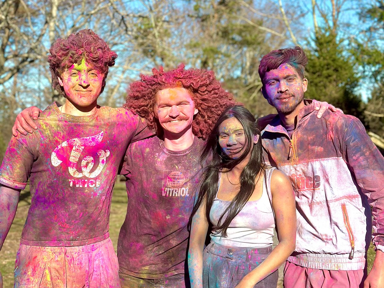 students covered in colourful powder celebrating Holi