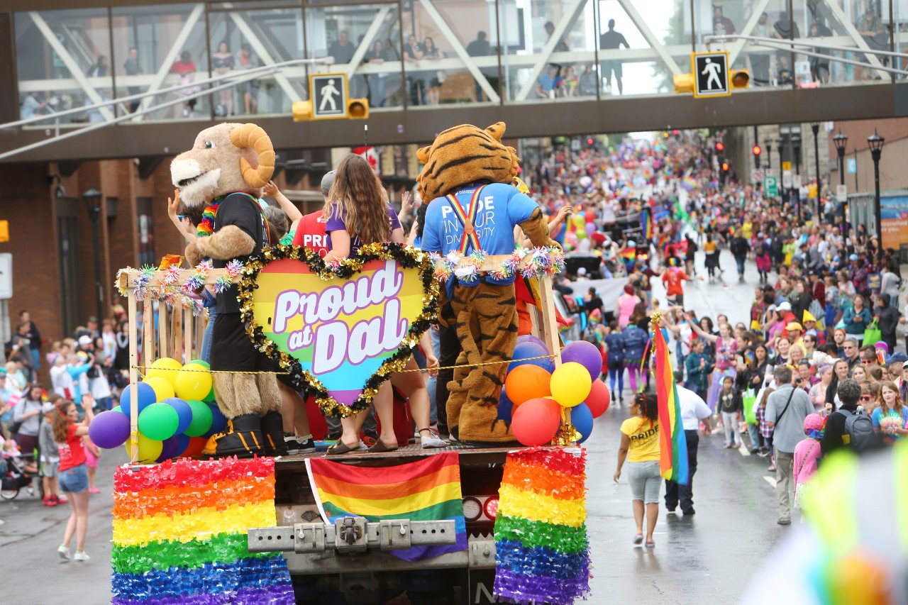 Rear view of Dalhousie students and mascots on a colourful float in the Halifax Pride Parade.