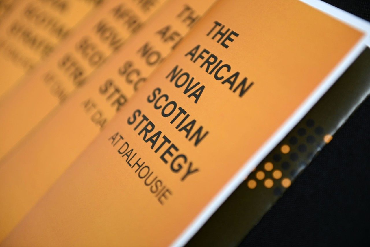 Stack of gold booklets with black lettering that reads "The African Nova Scotian Strategy at Dalhousie."