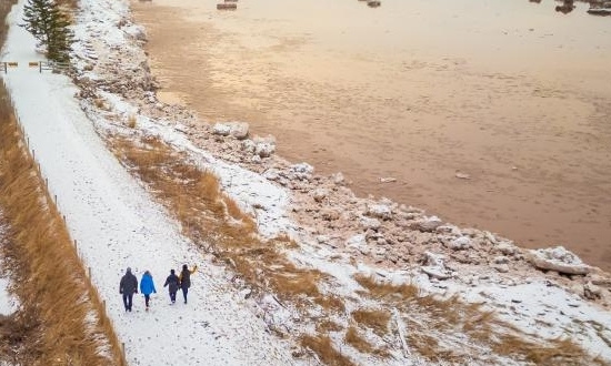 Four people walking in snow along the Shubenacadie River in Lower Truro