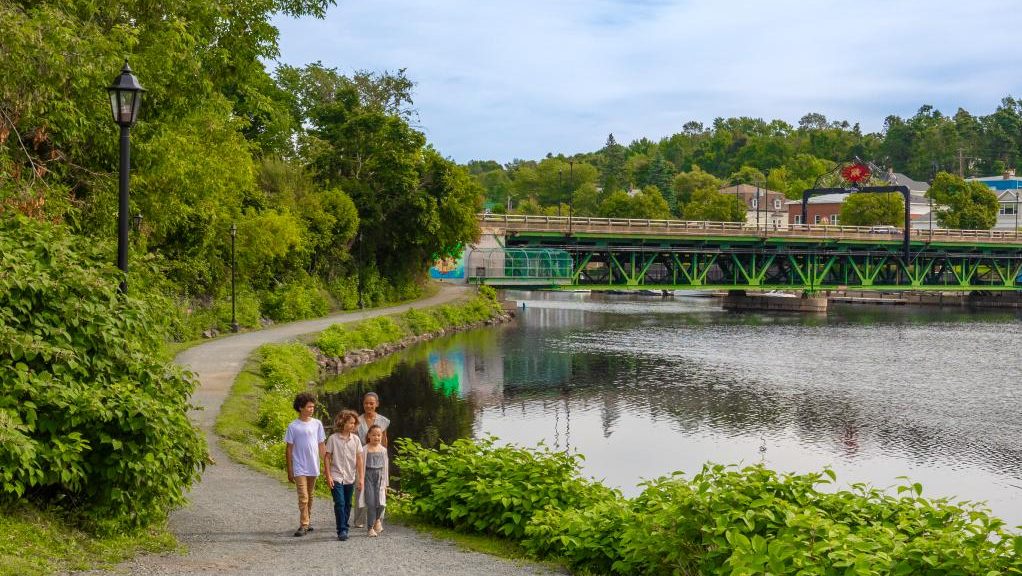Four people walking on a waterside trail in Pictou