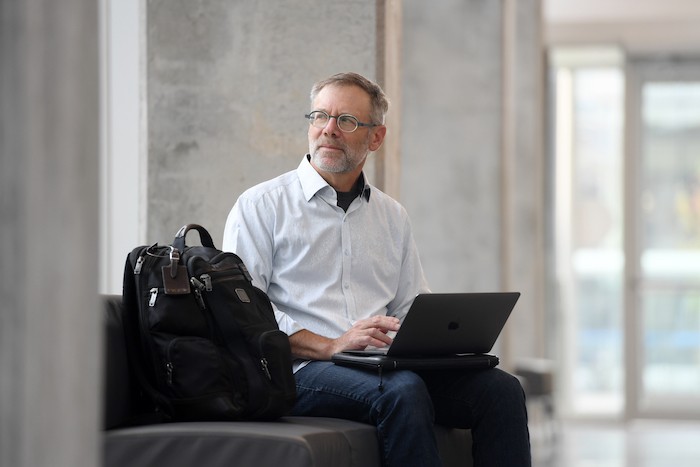 Michael Ungar sitting in a chair looking to the left