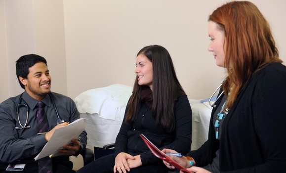 Volunteer patient sitting with two doctors.