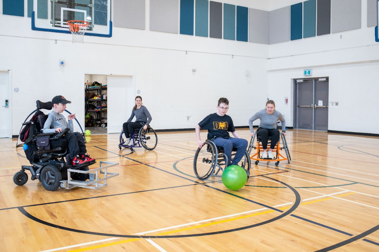 children in wheelchairs playing in a gym