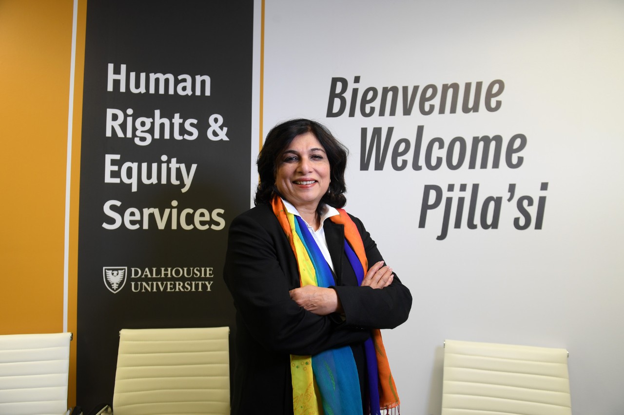 Theresa Rajack-Talley, Dalhousie’s vice-provost of equity and inclusion, stands with her arms folded in front of a sign that says Human Rights and Equity Services and Welcome in French, English, and Mi'kmaq.