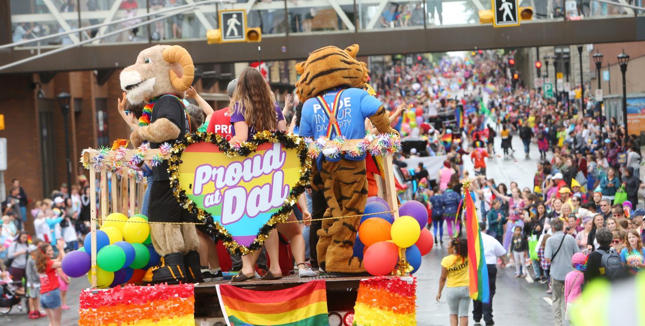 Rear view of Dalhousie students and mascots on a colourful float in the Halifax Pride Parade.