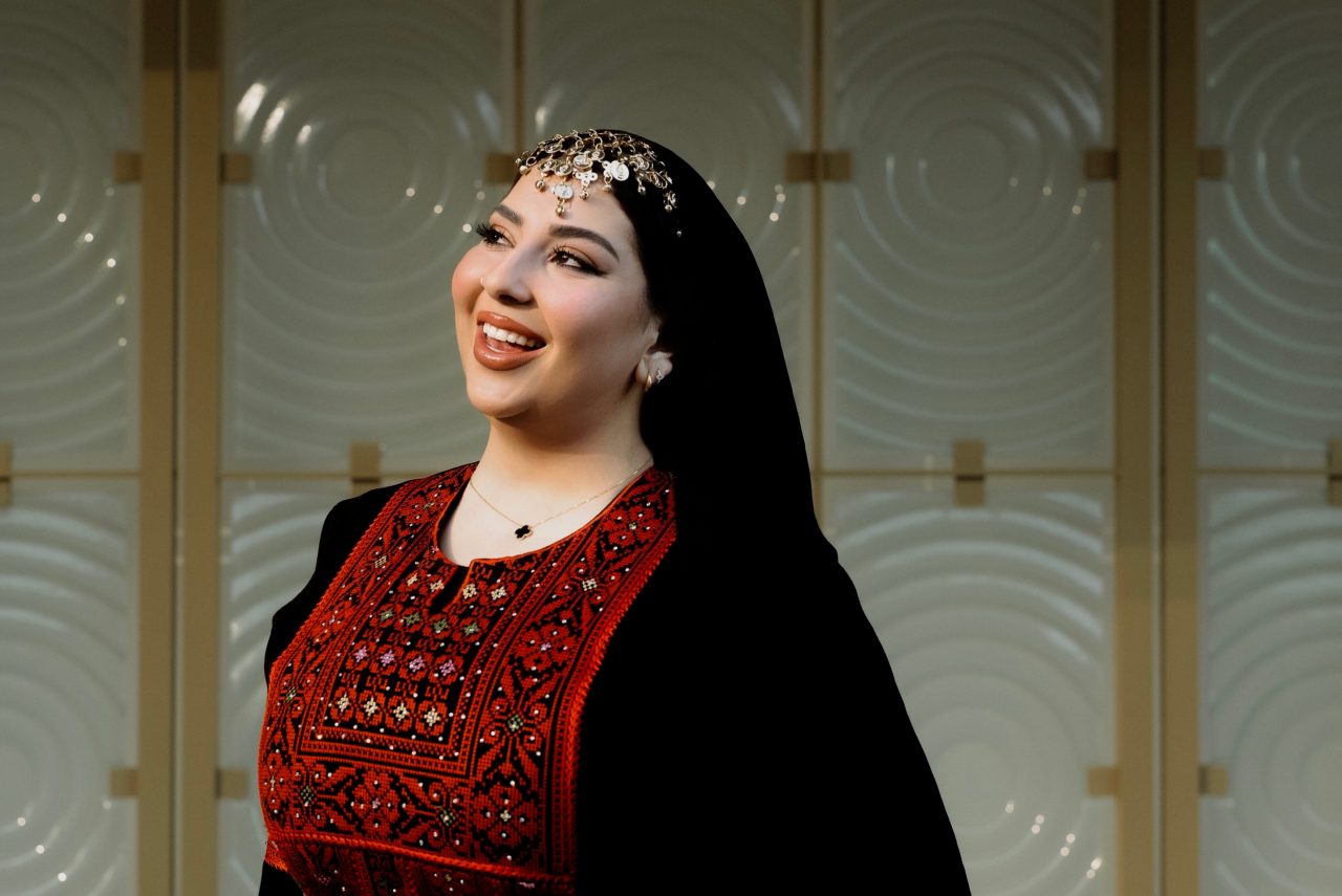 Dana Elborno wearing a black dress with red embroidery.