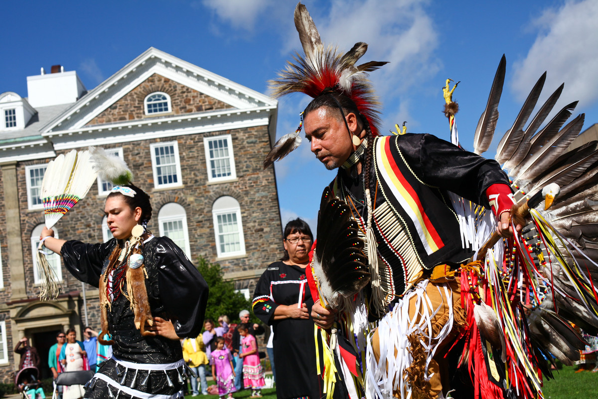 Mi'kmaq dancers in traditional dress participate in a Mawio'mi on a sunny day.
