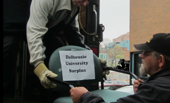 Employees move a chair marked Dalhousie University surplus goods.