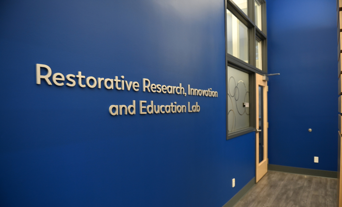 Blue wall with title of lab leading up to door.