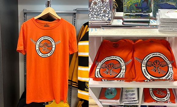 Orange shirts are on hangers and arranged on shelves at the Dal Bookstore.