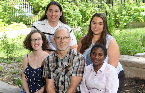 Group of faculty, staff, and students outside facing camera.