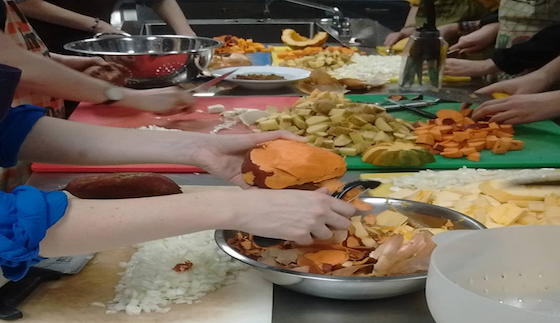 people's hands preparing vegetables