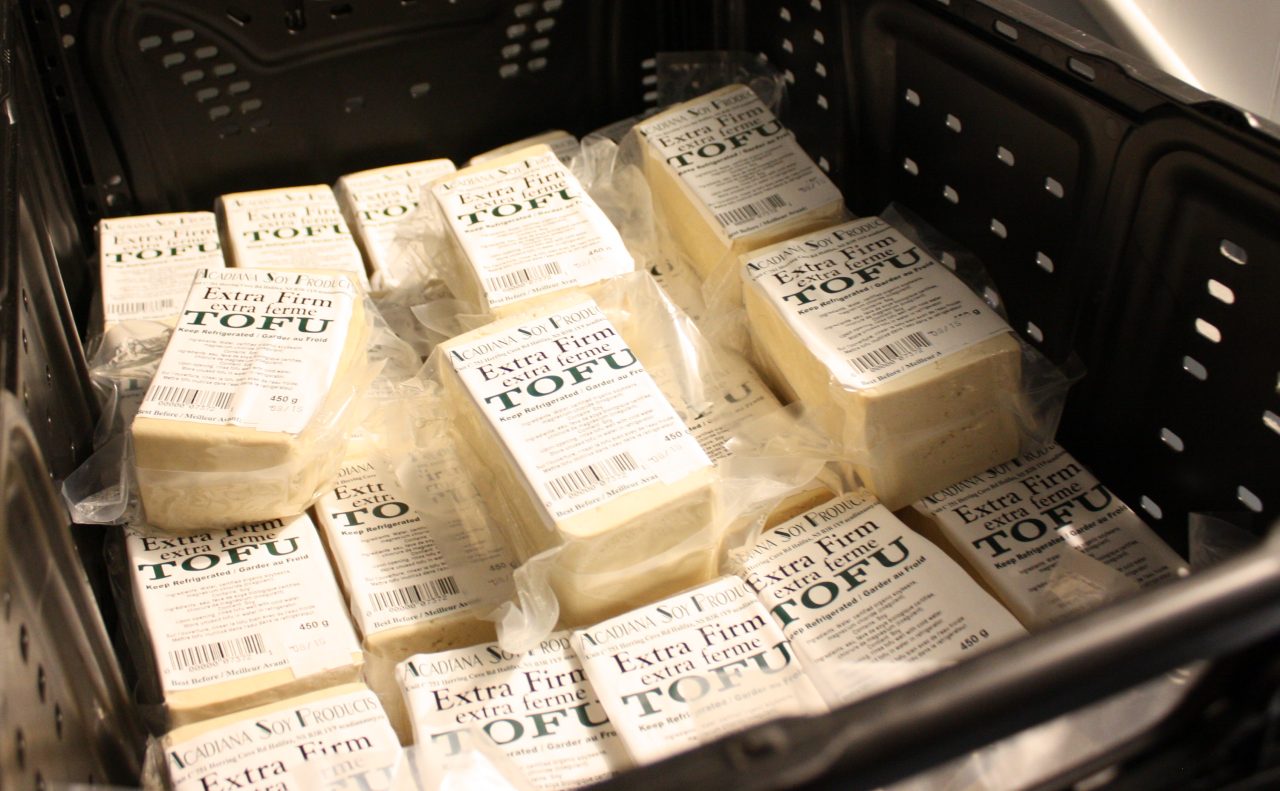 A dozen cubes of tofu in a black crate.