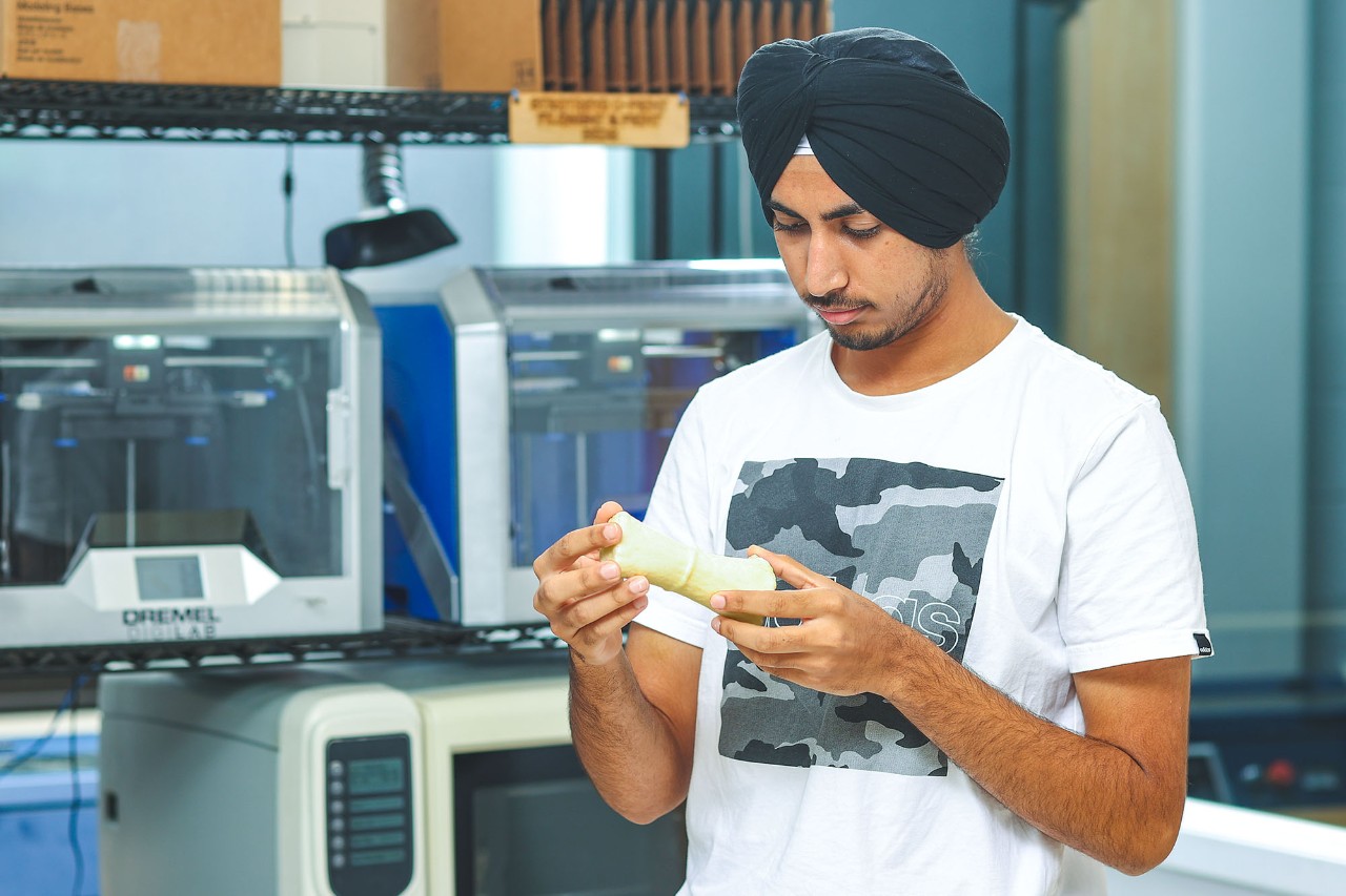Student in lab holding object.