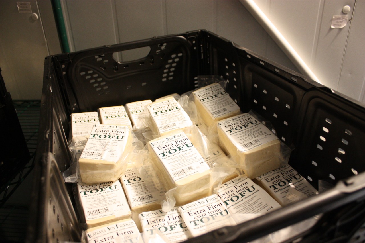 A dozen cubes of tofu in a black crate.