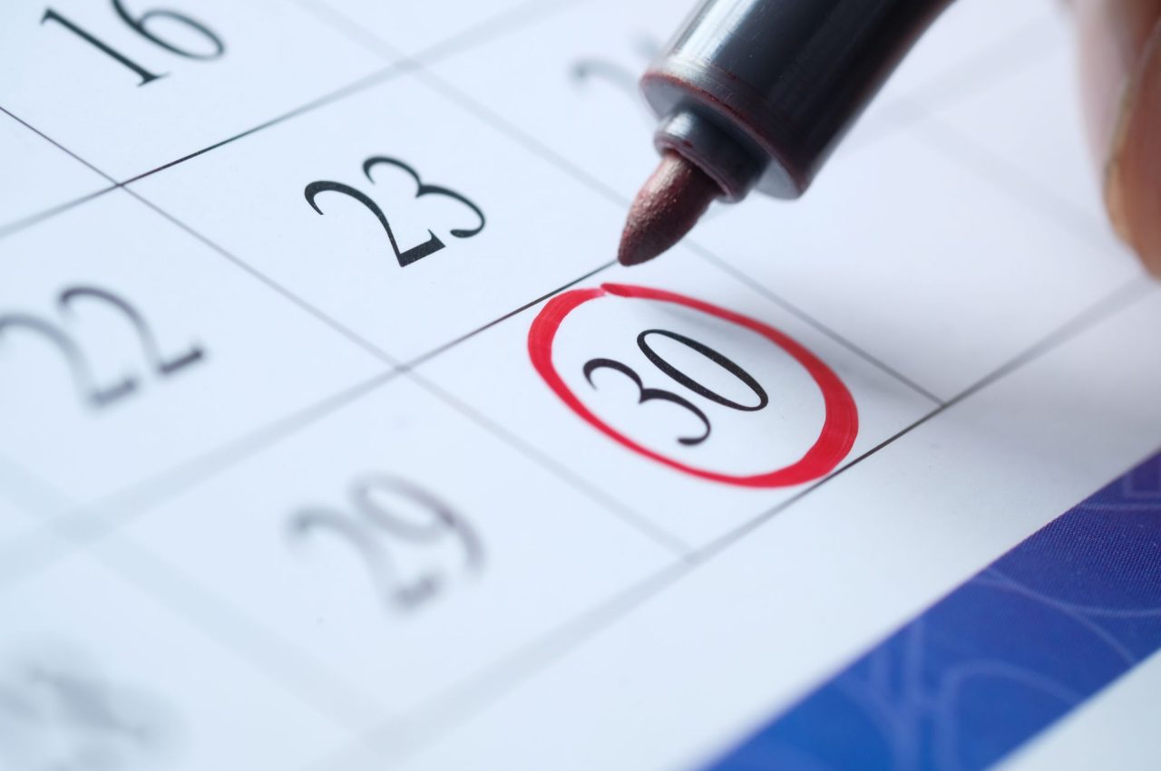 The date 30 is circled in red marker on a monthly calendar.