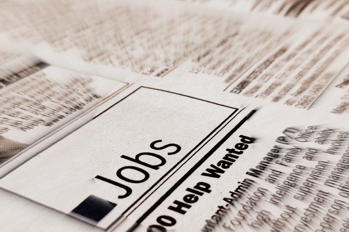 A blurry photo of a newspaper page that says Jobs above the words Help Wanted