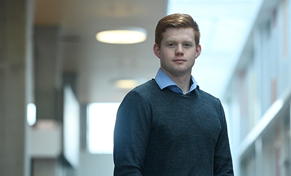 Portrait of Isaac Bahler wearing a dark sweater and blue shirt.