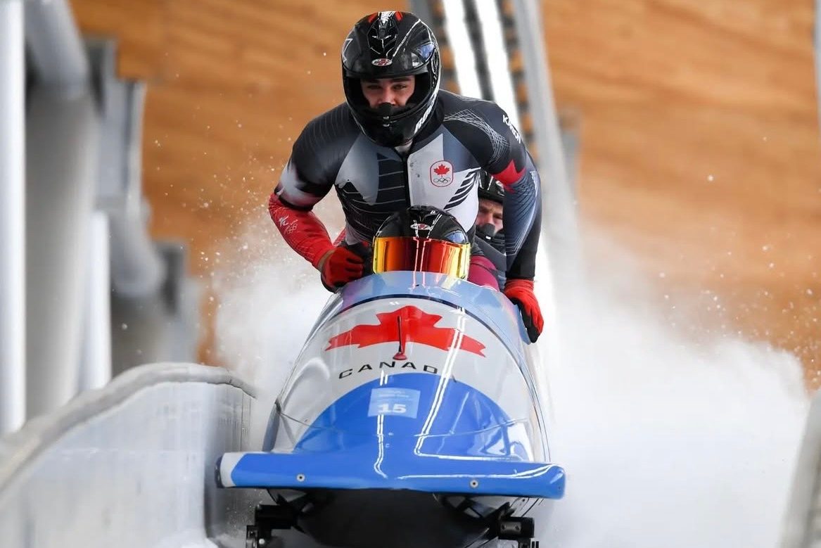 A fourman bobsleigh team in action on the track.