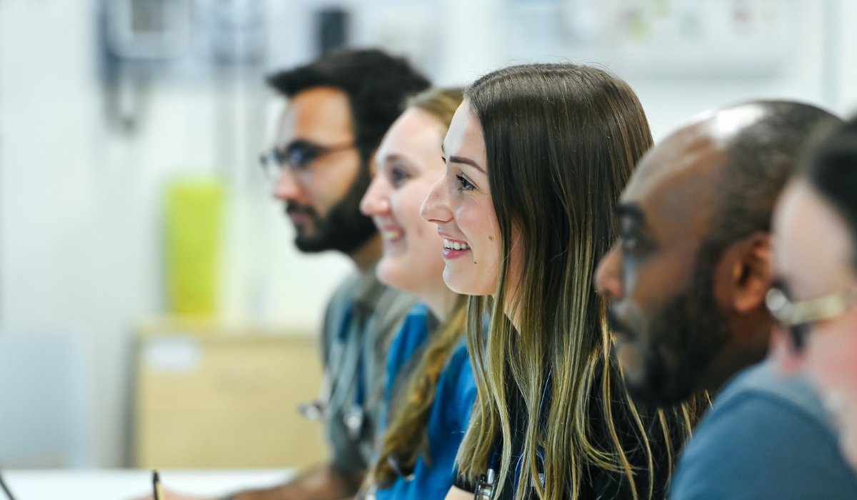 Several students sitting in a classroom close-up on faces.