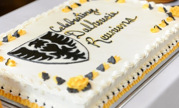A large sheet cake decorated with Celebrating Dalhousie Reunions and black and yellow icing.