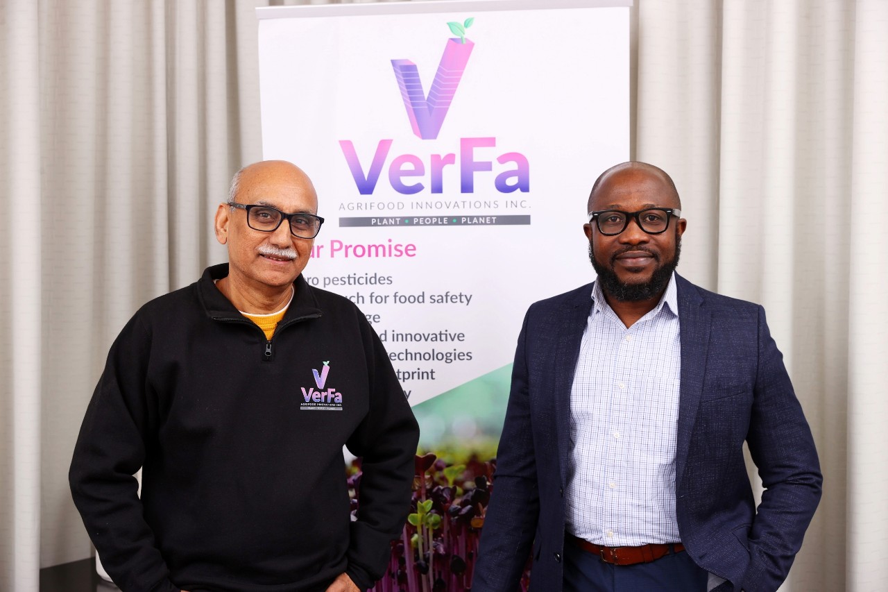 Lada and Korankye stand in from of a VerFa sign at an event.