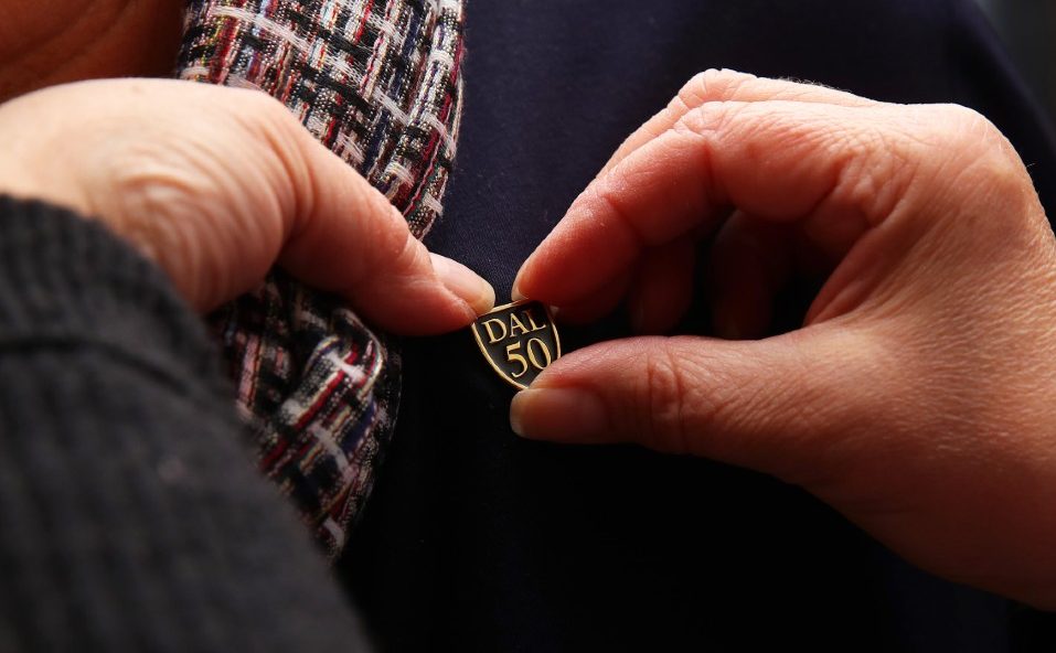 A group of Champagne Social attendees stand together on the stairs of Shirreff Hall.