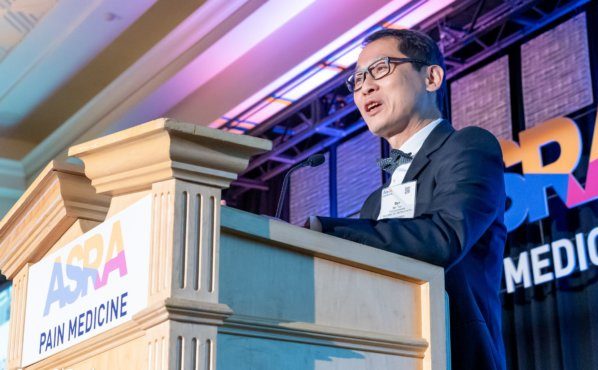 Dr. Ban Tsui speaks at a podium during the American Society of Regional Anesthesia and Pain Medicine awards.