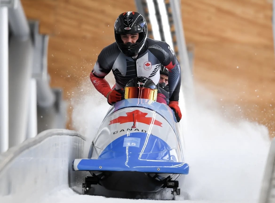 A fourman bobsleigh team in action on the track.