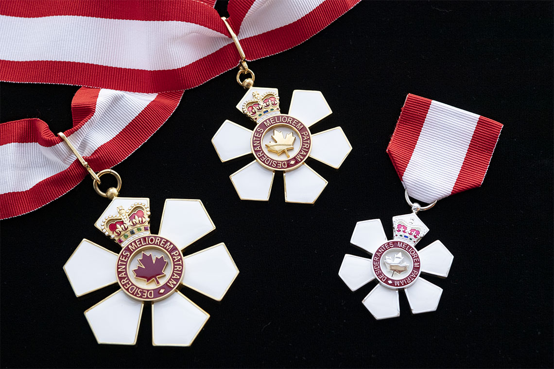 Three medals of the Order of Canada on a black background.