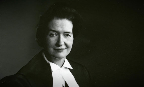 Black and white portrait of Bertha Wilson in judge's robe with a half smile.