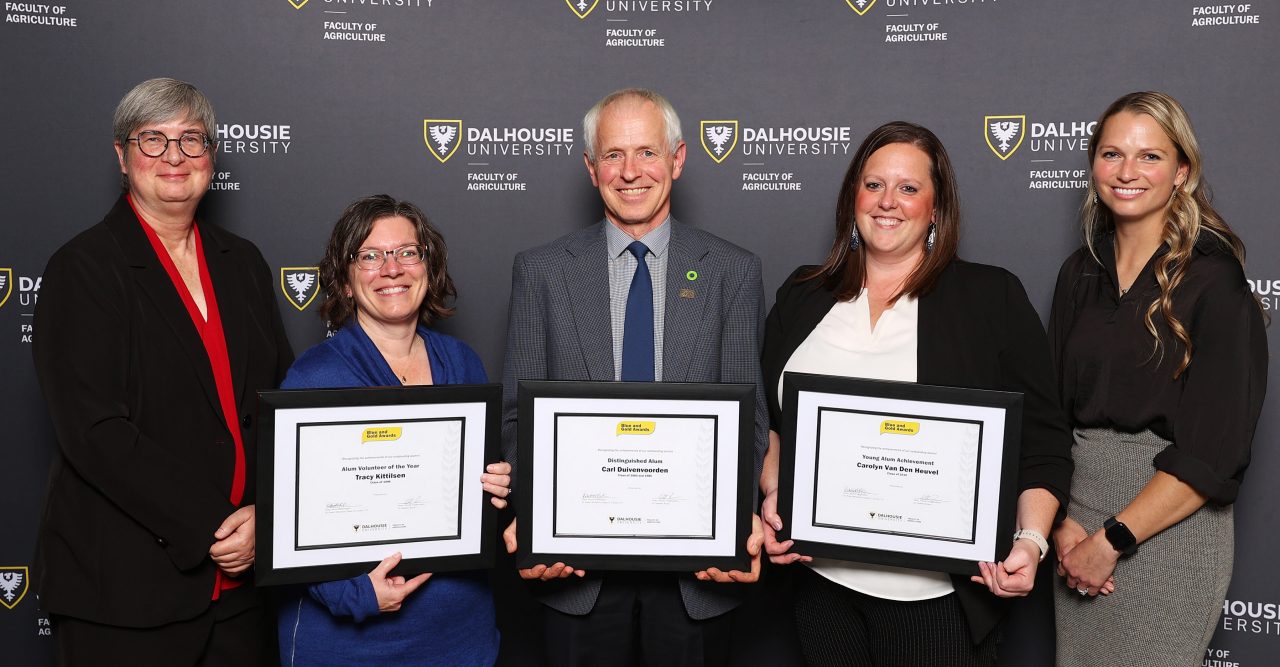 Award recipients pose with their framed certificates, the dean and an alumni association member at the event.