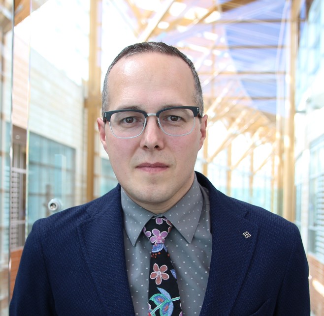 Mushquash in business formal attire.