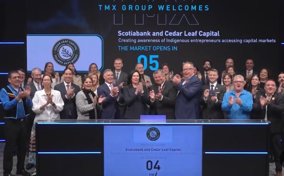 Group of people at TMX trading podium applauding a market open for Scotiabank and Cedar Leaf Capital, with branding displayed on large screens.