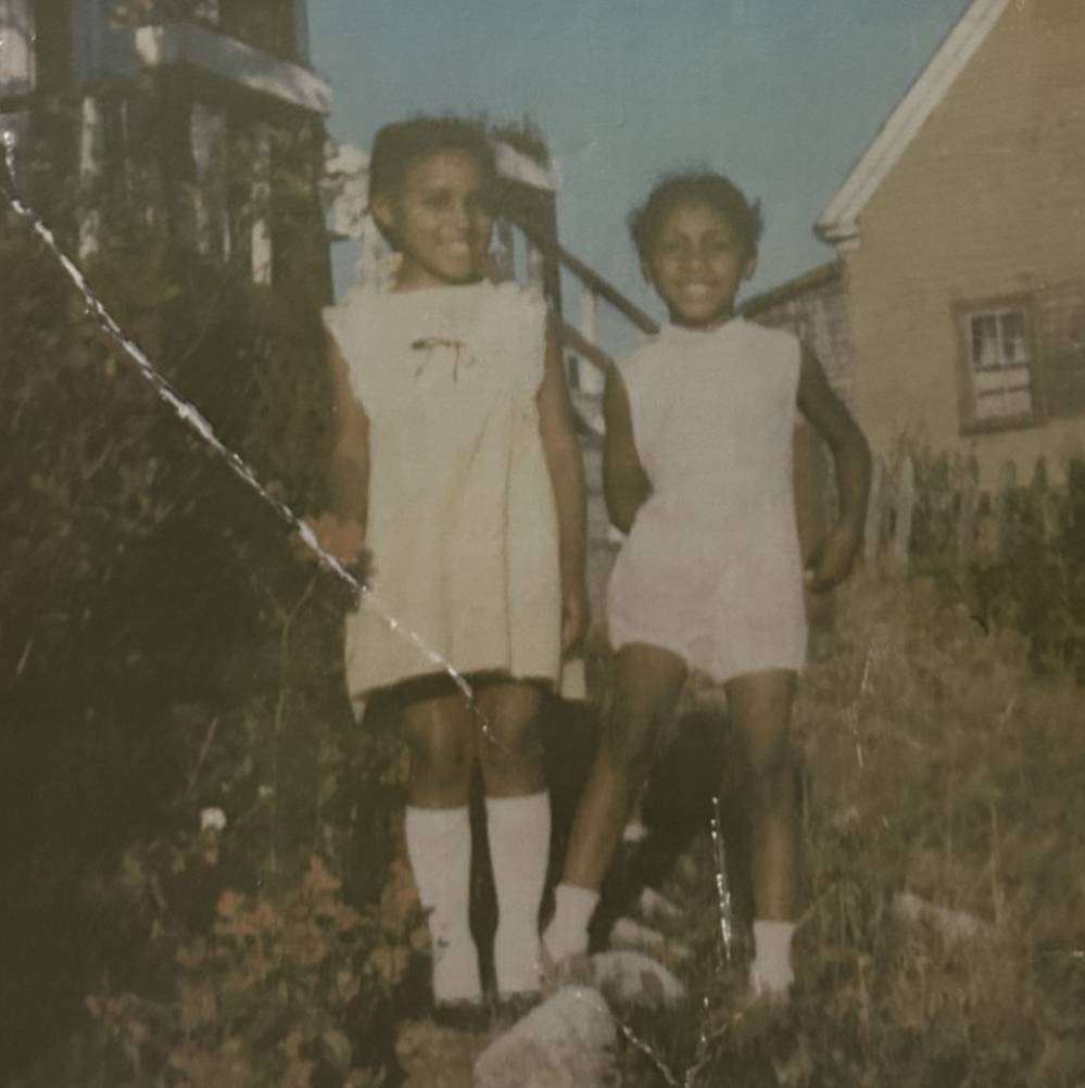 An archival photo of two children smiling outdoors.