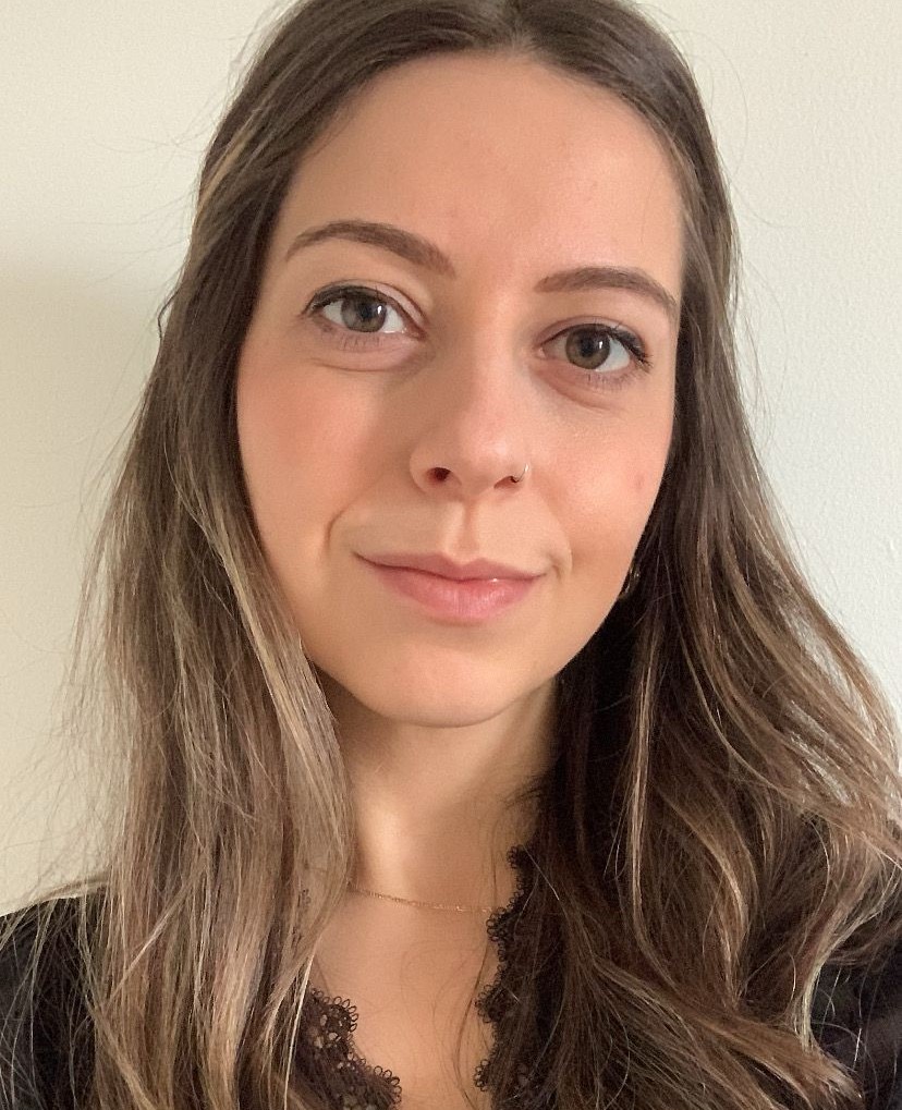 A headshot of a woman with long brown hair and brown eyes