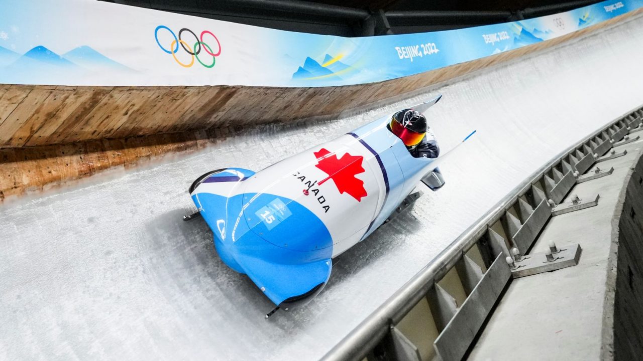 A bobsled for Team Canada and occupants sliding down an Olympic track. 