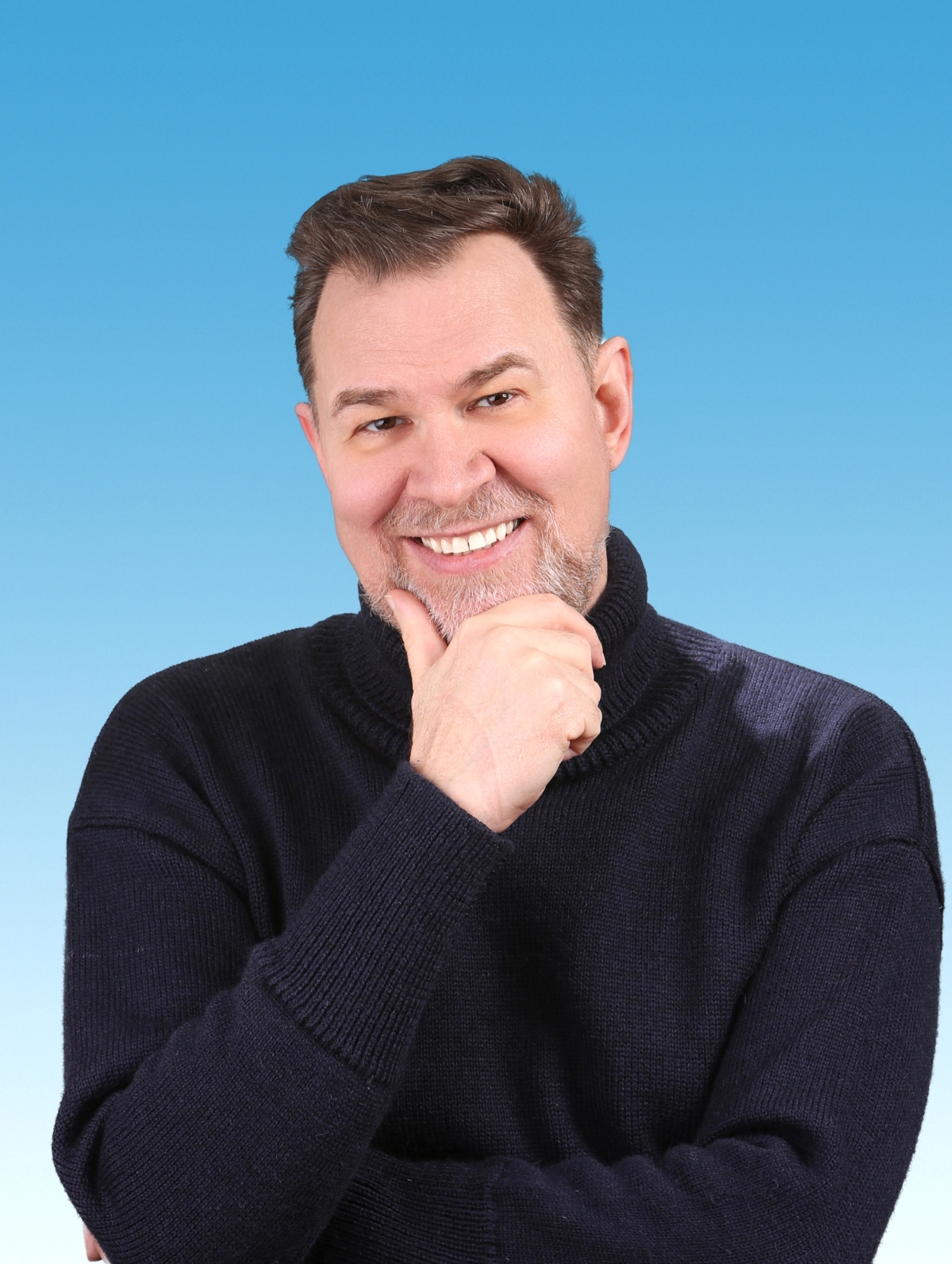 A portrait of Thompson smiling with his hand on his chin. 